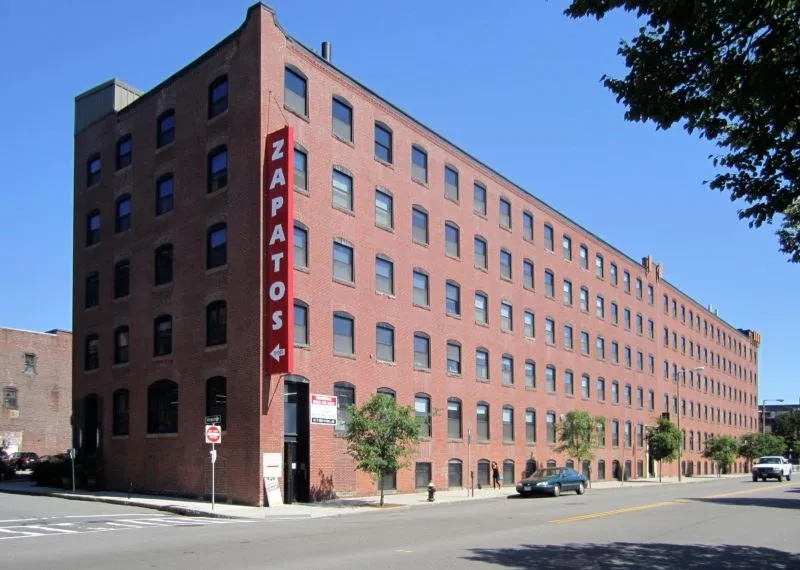 Renovated brick mill building with a vertical sign, a commercial project by Abrams Builders