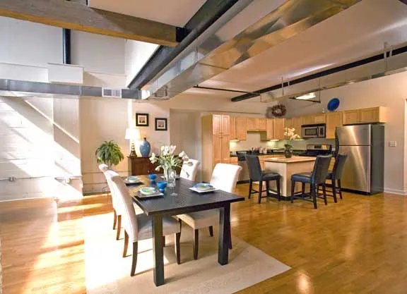 Loft living and dining area with exposed beams and ductwork at the Fremont Lofts